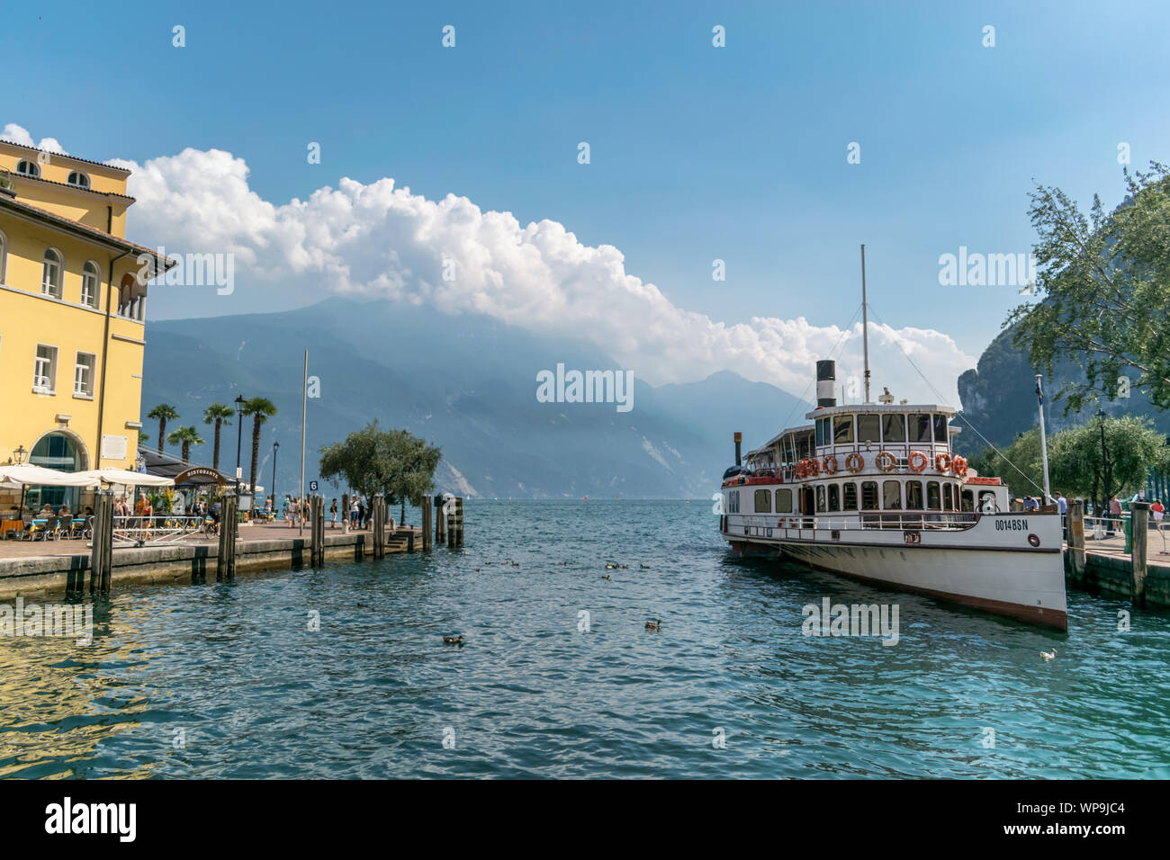 Riva del Garda, Italy -  Aug 1, 2019: An old paddle steamer boat docked at the harbour in Riva del Garda on Lake Garda Stock Photo