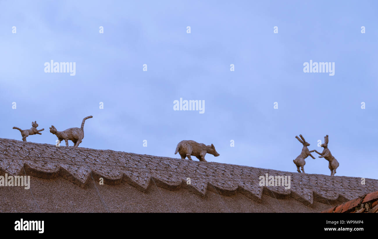 Straw finials of animals on a thatched roof Stock Photo Alamy