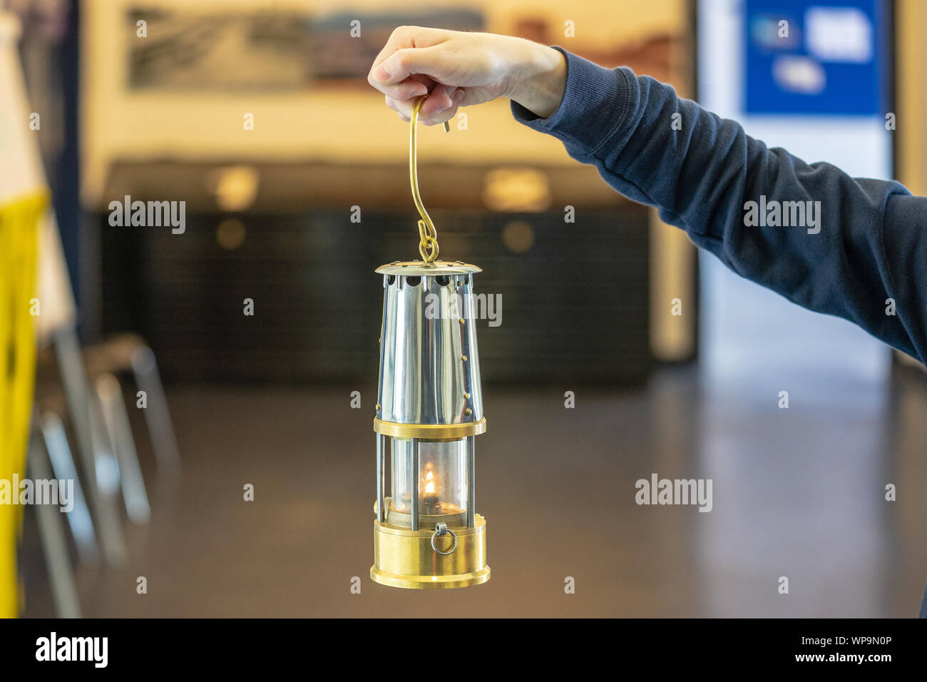 Hand holding Original Miners Flame Safety Lamp. Flame safety lamp used