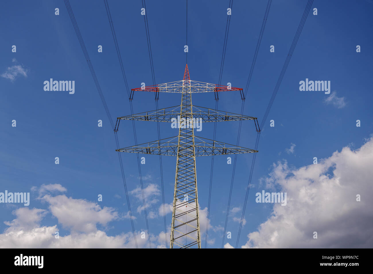 Low angle view of high voltage post and electric cable against sunny ...
