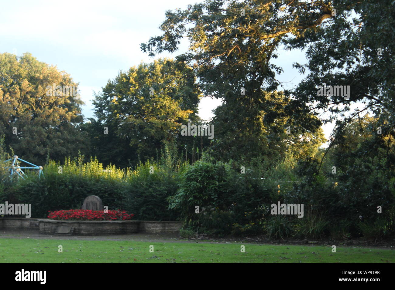 Trees, bushes and flowers in pretty gardens on a sunny day Stock Photo
