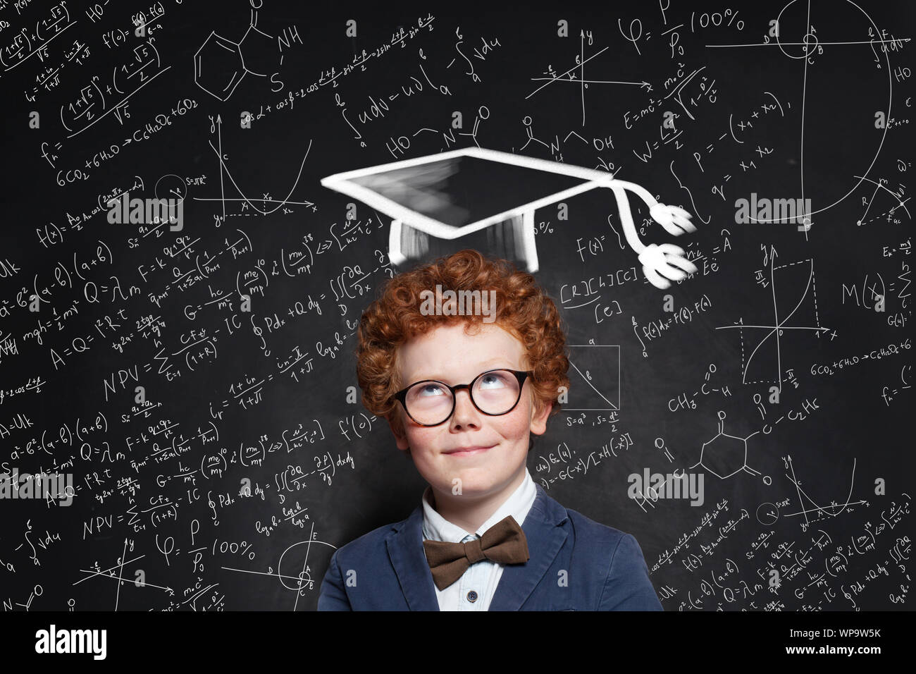 Successful kid schoolboy in graduation hat on science background Stock Photo