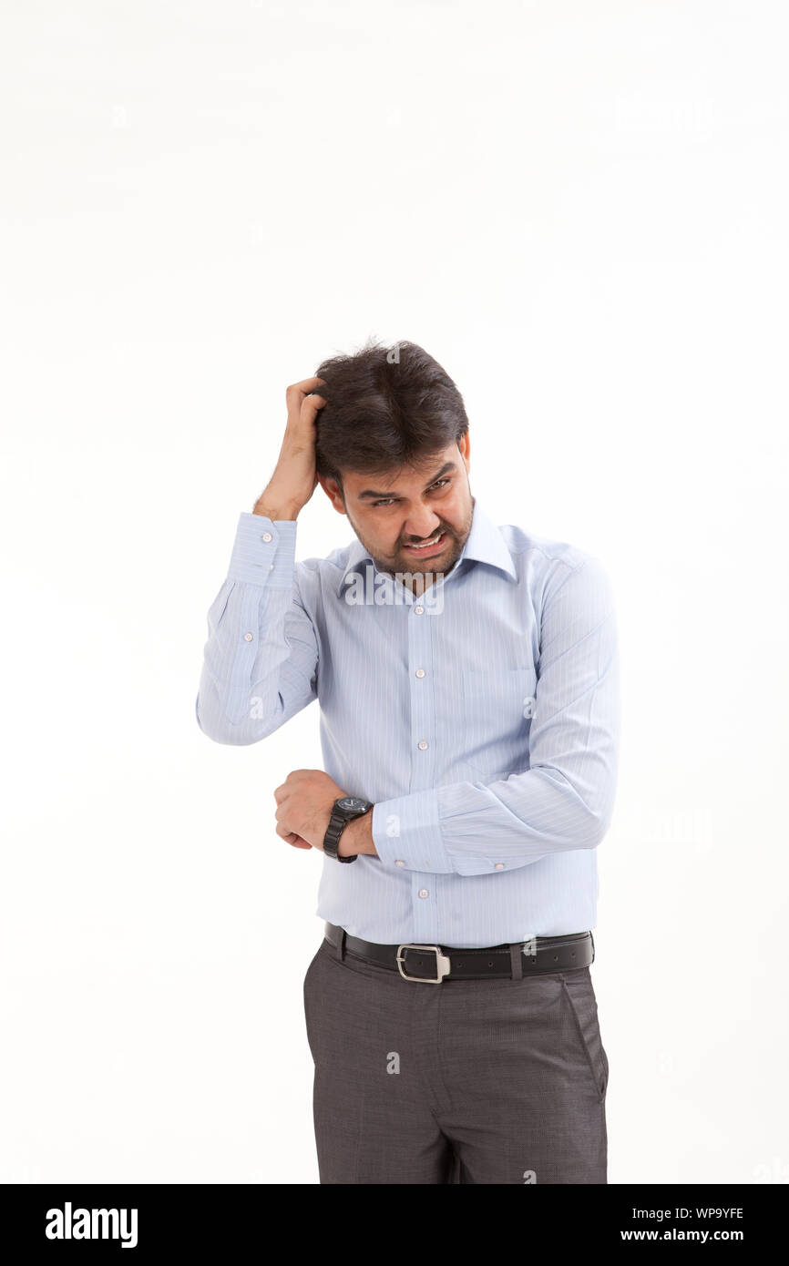 Frustrated young man scratching his head Stock Photo