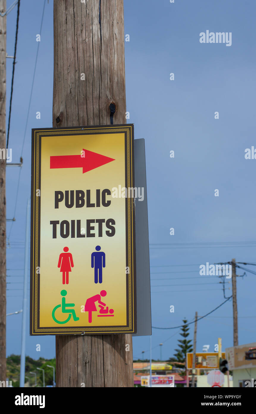 Road sign on a pole with common symbols and the inscription 'public toilets' (Greece) Stock Photo