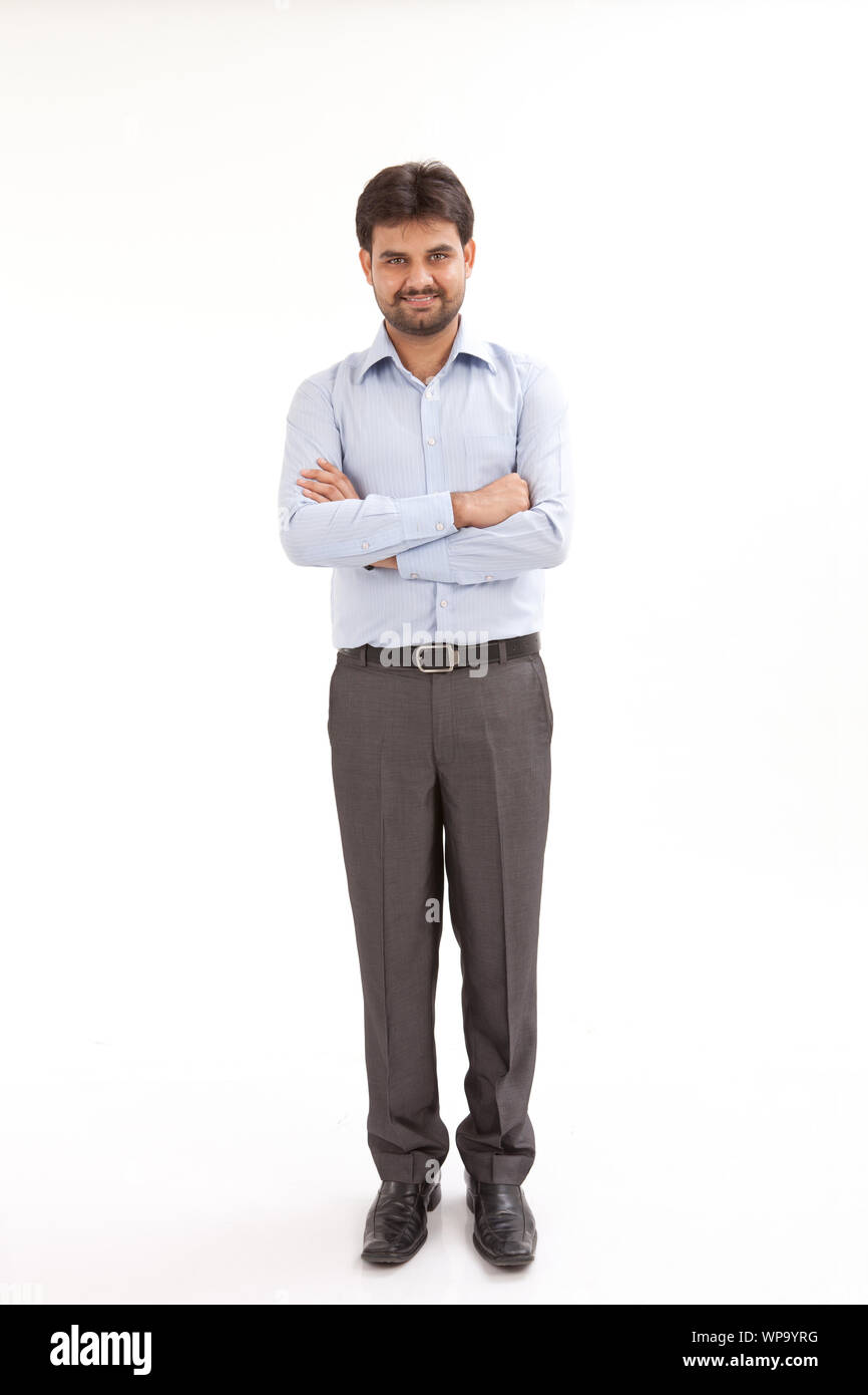 Portrait of a young man standing with his arms crossed Stock Photo Alamy