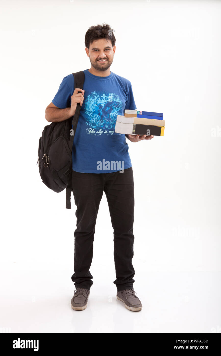 College student standing with books and backpack Stock Photo - Alamy