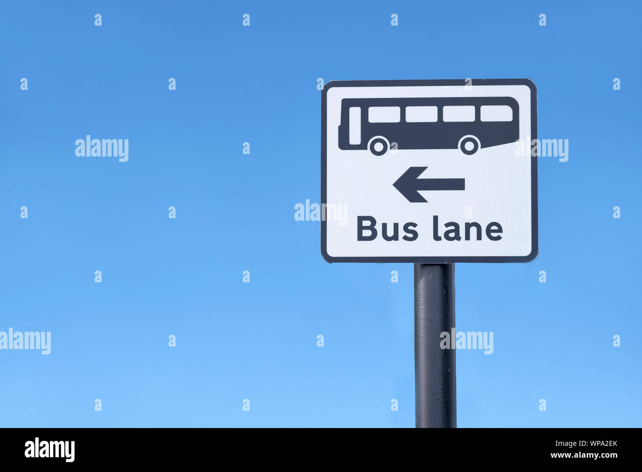 Bus lane symbol sign and direction arrow against blue sky uk Stock Photo