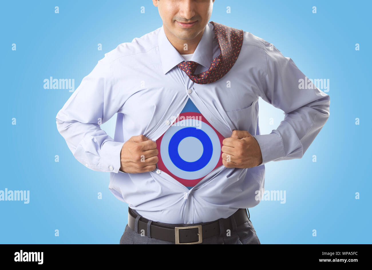 Super businessman tearing up his shirt to reveal dartboard on chest Stock Photo
