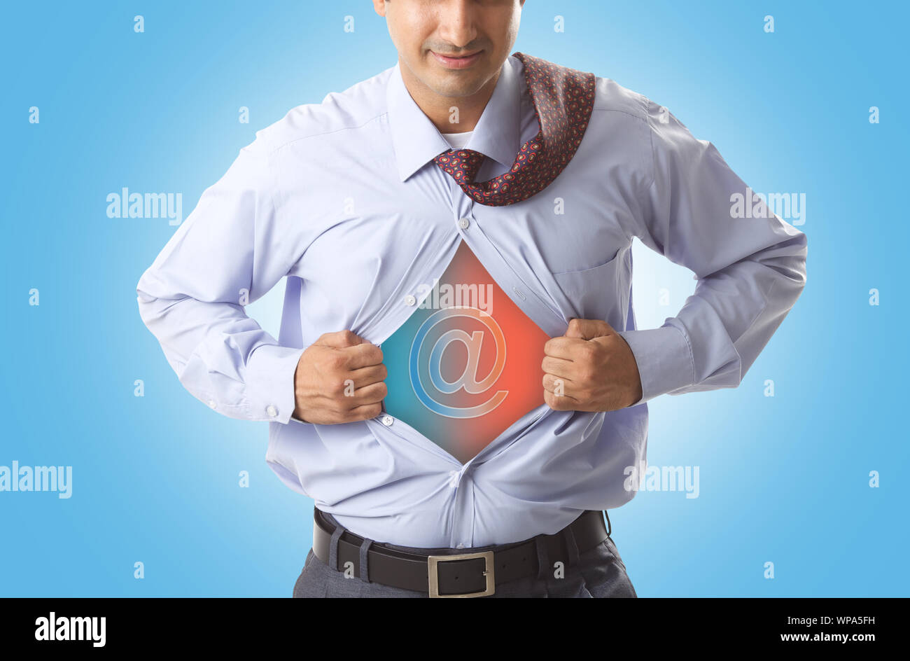 Super businessman tearing up his shirt to reveal at symbol on chest Stock Photo