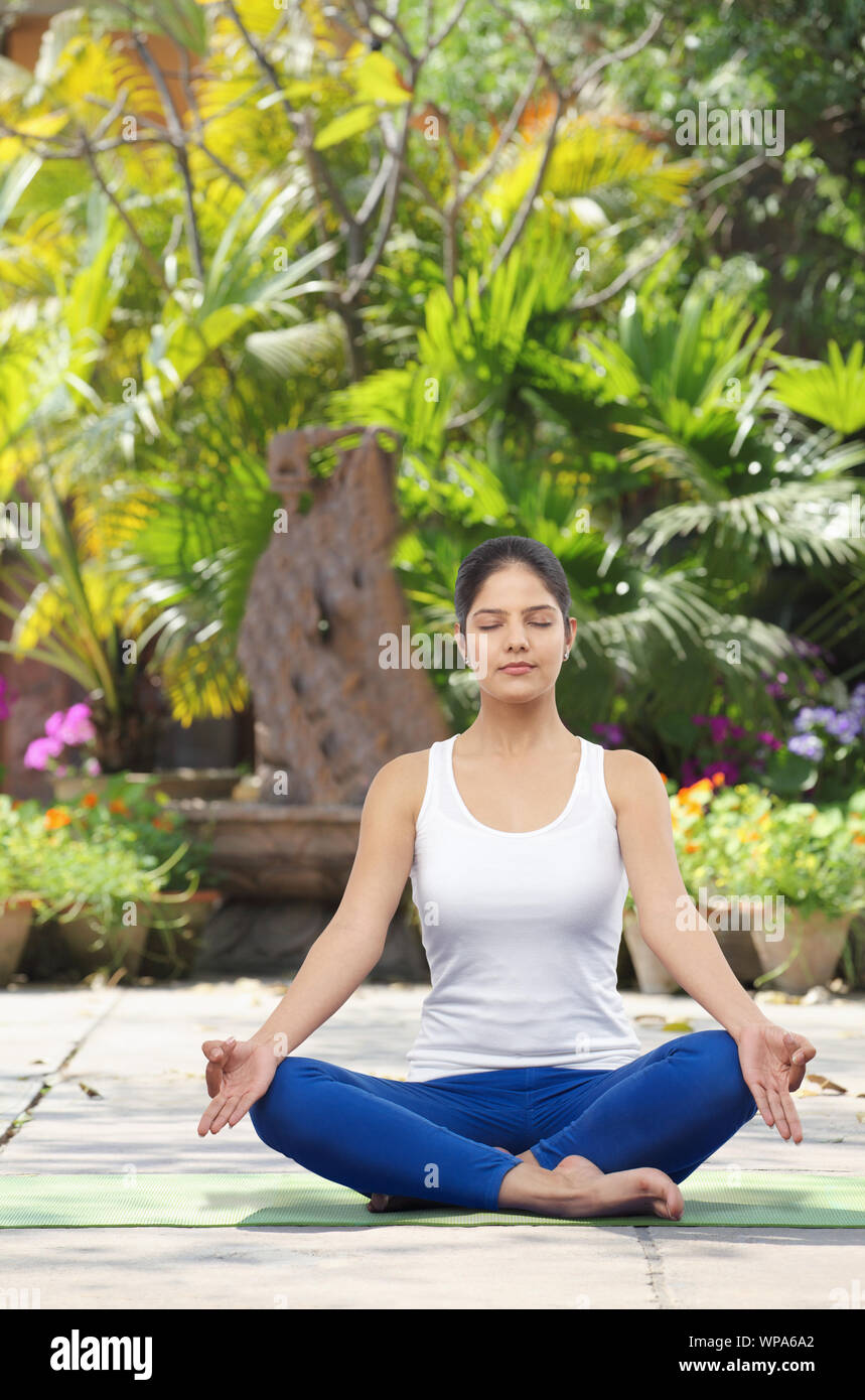 Young woman practicing yoga in a lawn Stock Photo