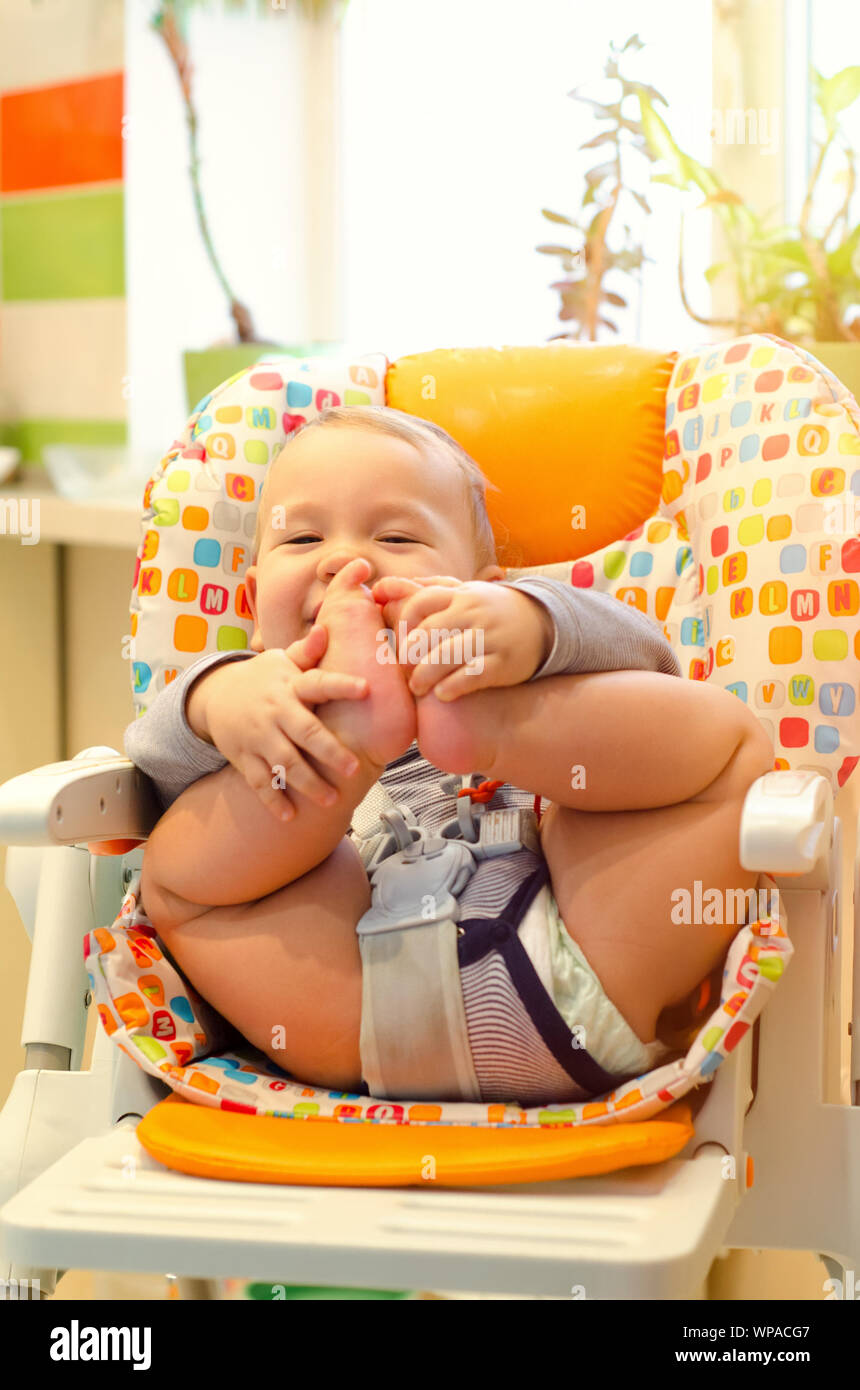 smiling baby boy sitting in the highchair Stock Photo Alamy