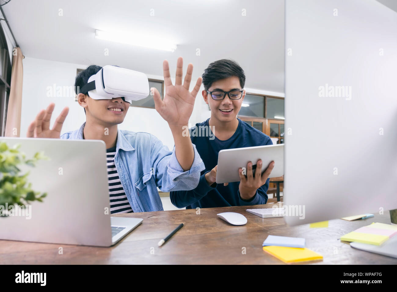 Young IT engineer and programmer testing software and working with Virtual Reality headset on. Programming, Software development, Education, VR, Tutor Stock Photo