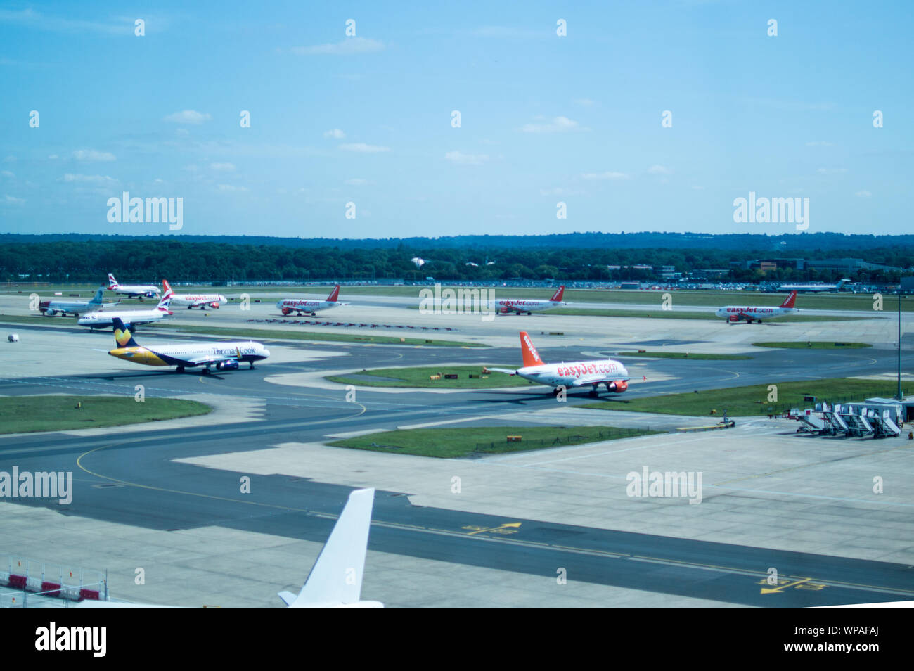 Easyjet, ThomasCook and British Airways planes line up at taxiway next to Gatwick runway for departure Stock Photo