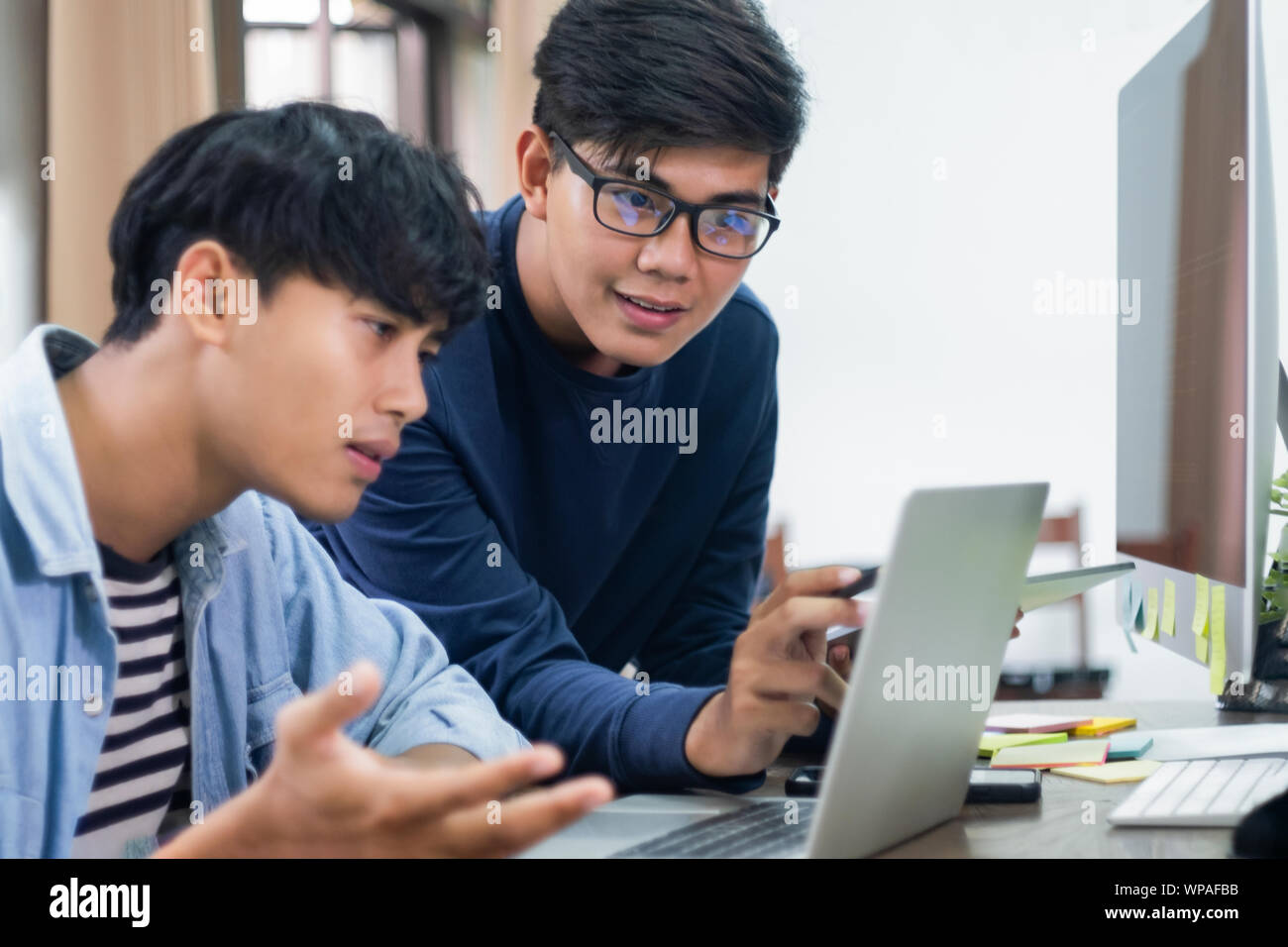 Programmers and developer teams are coding and developing software. Stock Photo