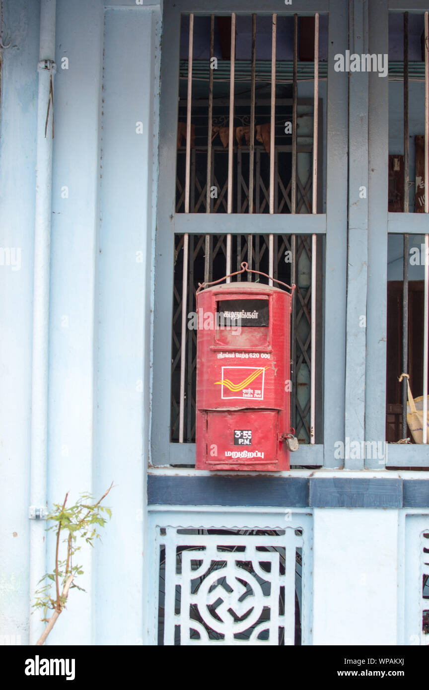 A red post box of India post hanging on a house window grill Stock Photo