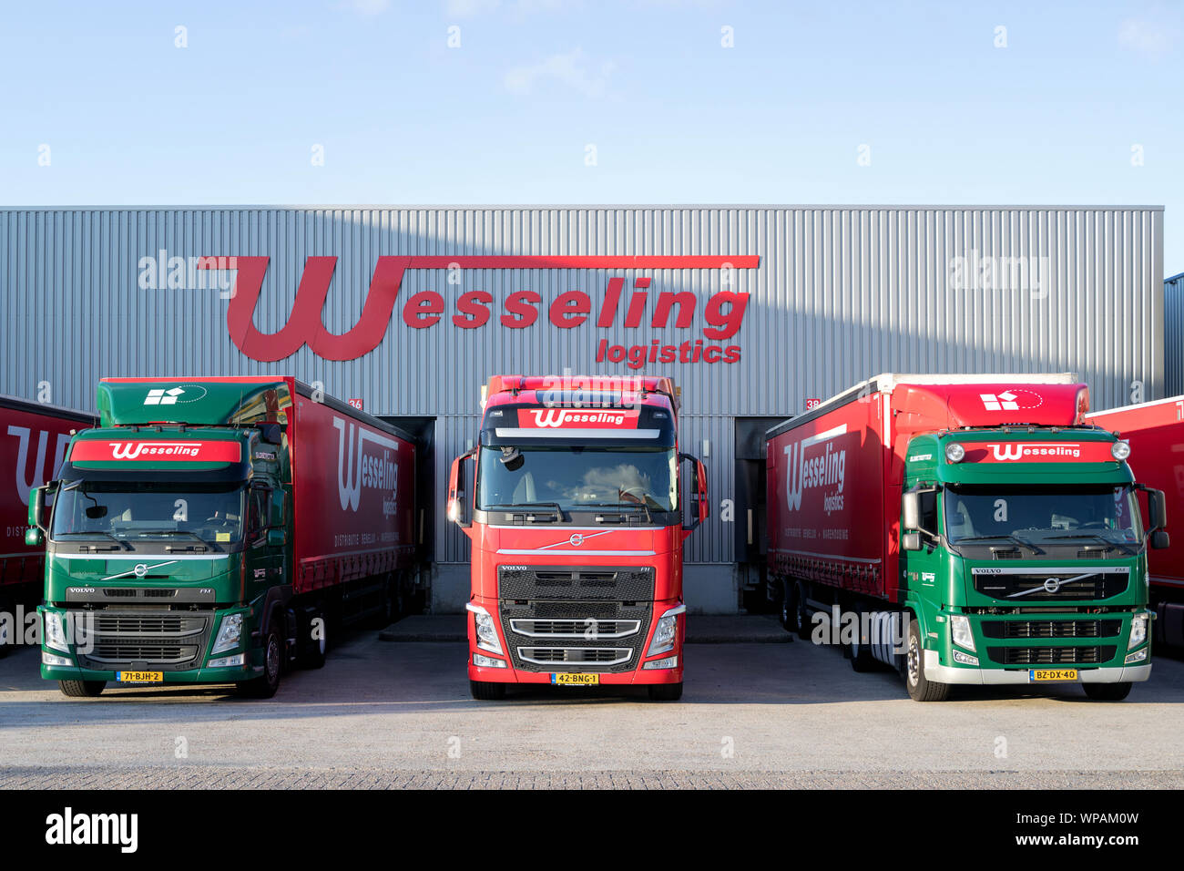 Wesseling trucks at warehouse. Wesseling Ligistics is a medium-sized family business with more than 100 years of experience. Stock Photo