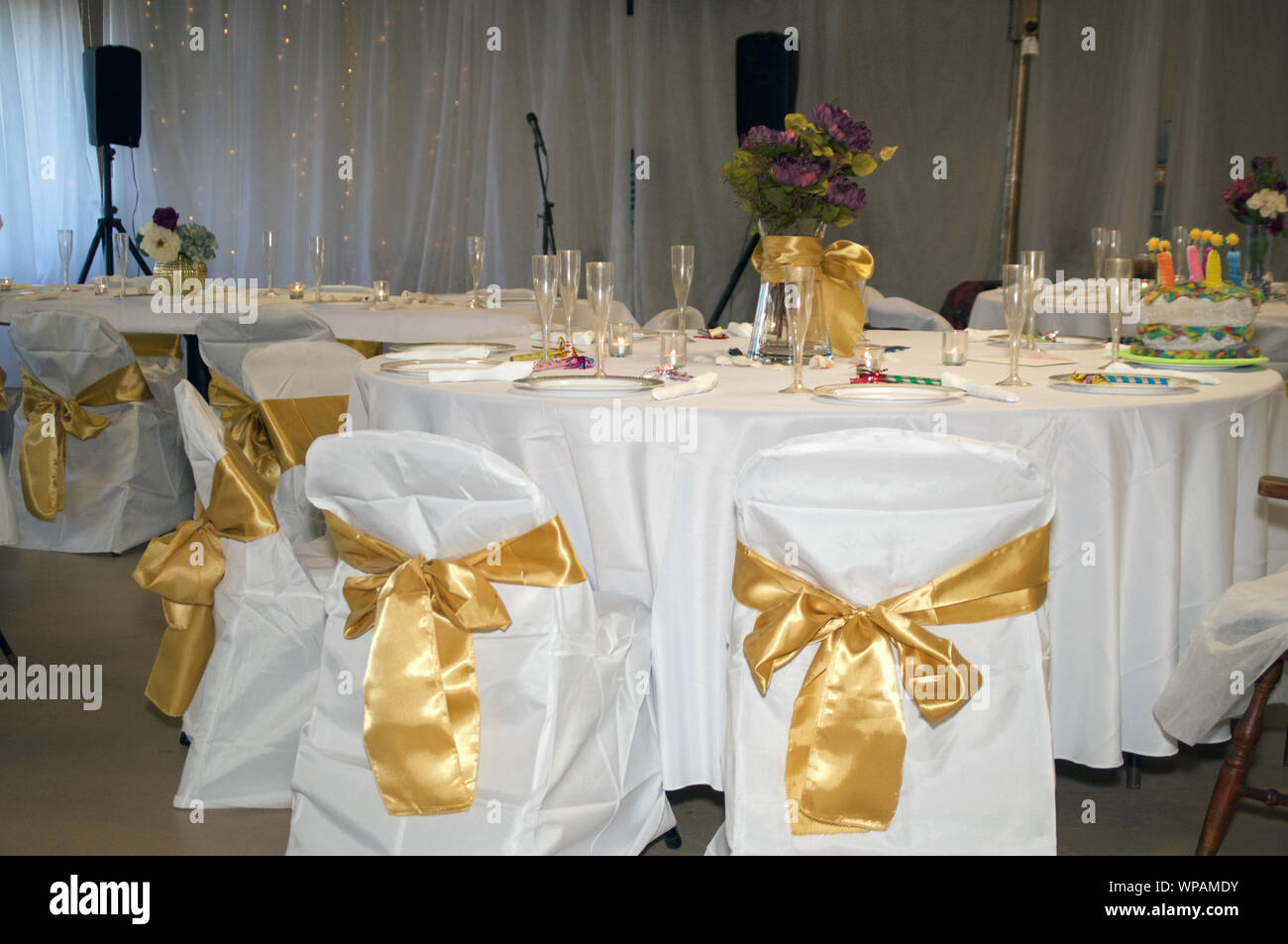 Wedding Reception Party Showing Covered Chairs With Gold Bows