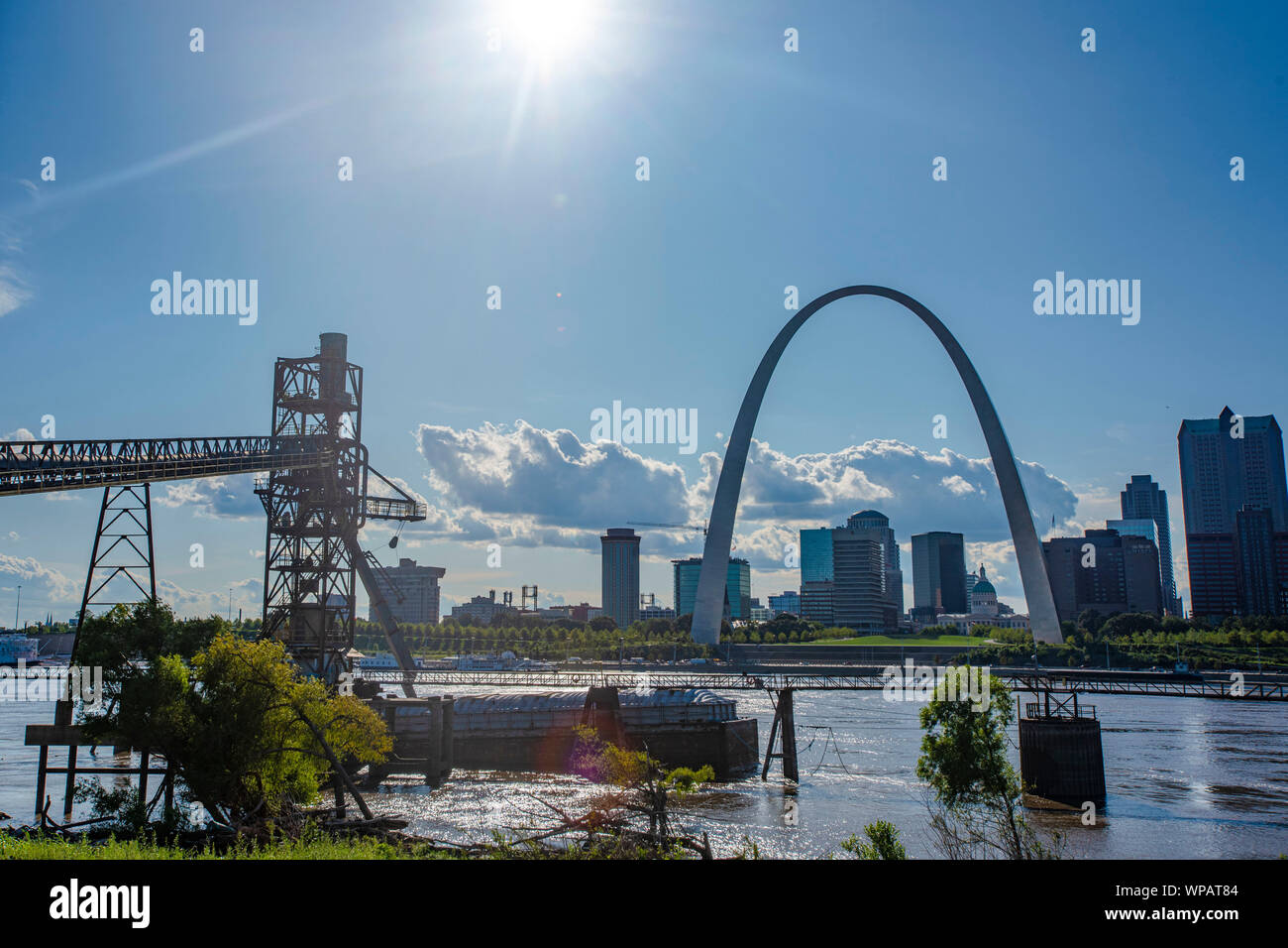 Barge traffic on the Mississippi River pass the Gateway Arch National Monument August 27, 2019 in St. Louis, Missouri, USA. A typical barge carries 1500 tons of cargo, which is 15 times greater than a rail car and 60 times greater than one trailer truck. An average river tow on the Mississippi River is 15 barges consisting of 5 barges tied together and moving 3 abreast. The same load would require a train 3 miles long or line of trucks stretching more than 35 miles. Stock Photo