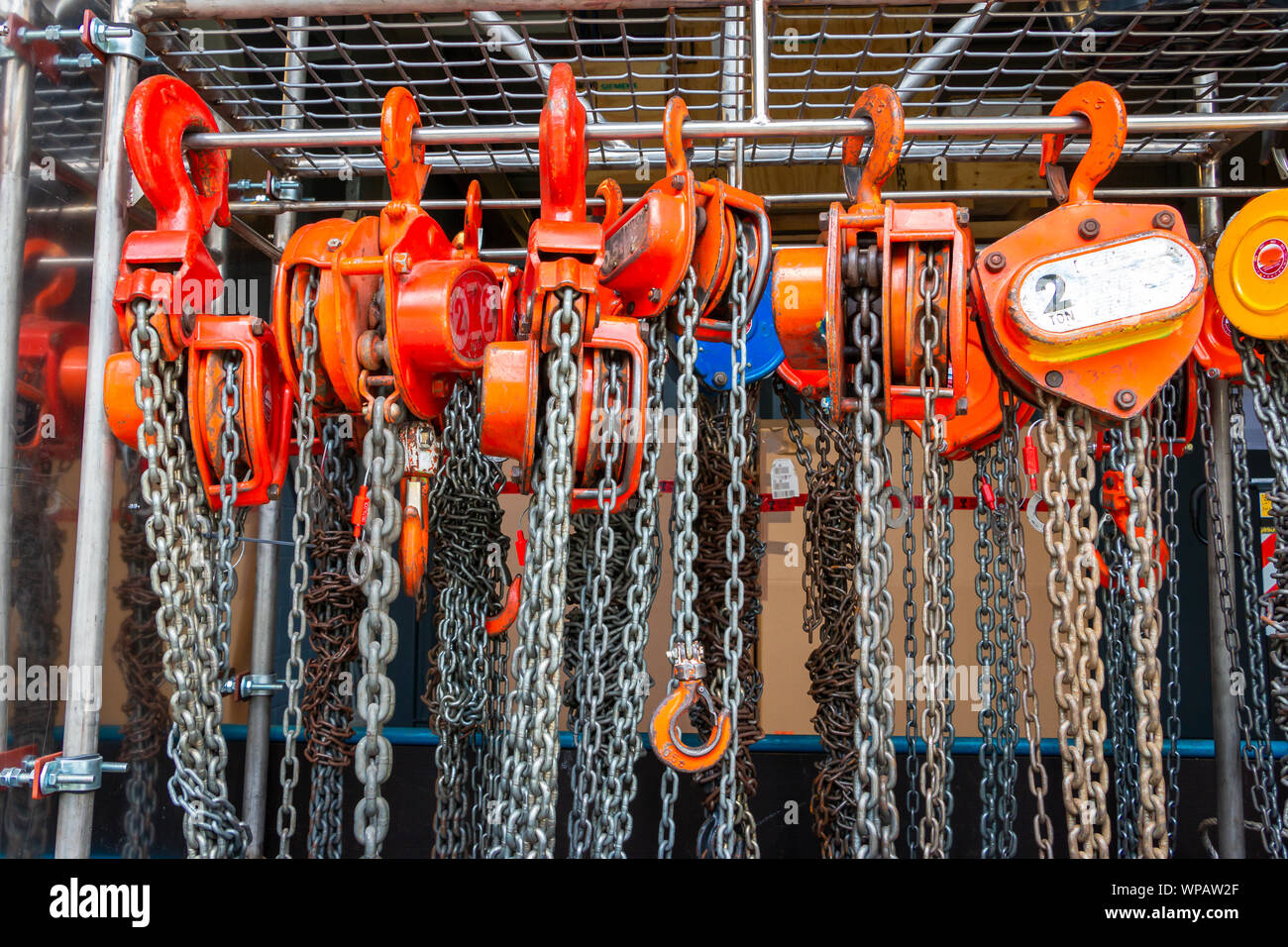 Multiple chain hoists hanging in a rack ready for use in a industrial ...