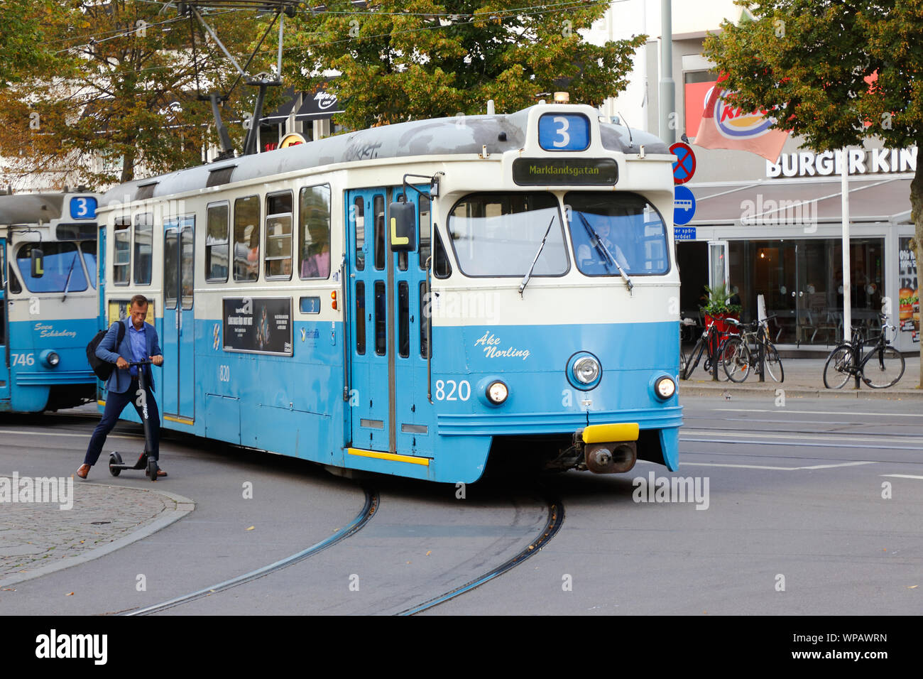 Gothenburg, Sweden - September 2, 2019: Tram of class M29 and man on an electric scooter. Stock Photo