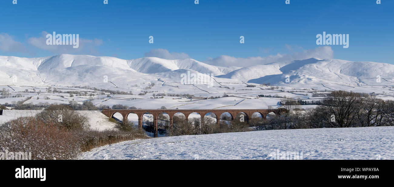 The disused Firbank viaduct with the Howgill Fells in the background, covered in snow. Cumbria, UK. Stock Photo