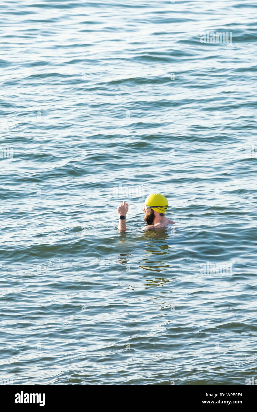 Aberystwyth Wales UK, Sunday 08 September 2019  UK Weather: A man swims in the sea off the beach on a very warm September evening in Aberystwyth Wales, as a brief interlude of high pressure brings fine weather to the UK for one day. Photo credit Keith Morris / Alamy Live News Stock Photo