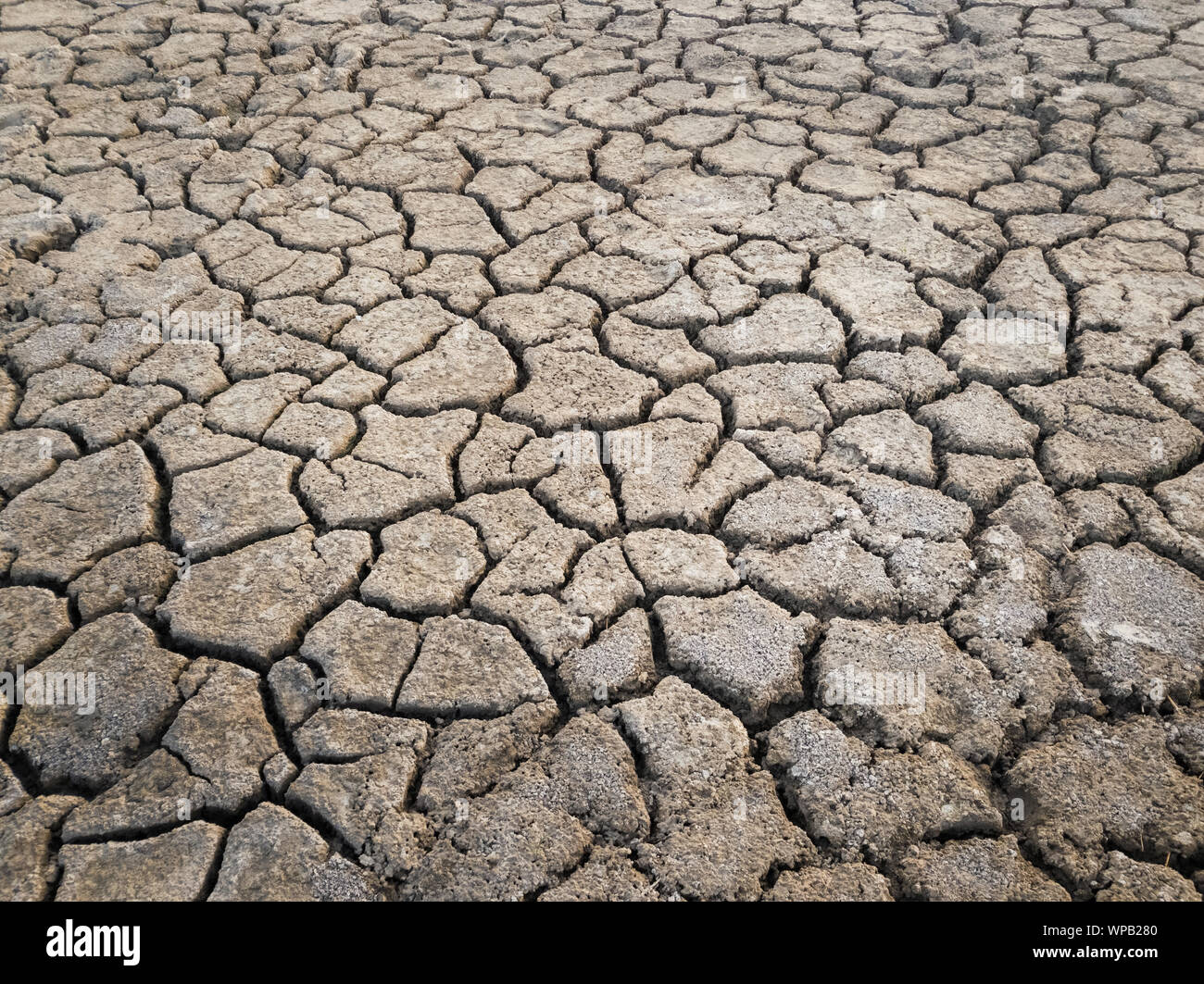 Dry and broken clay ground during drought season, concept of global warming problem. Cracked and barren soil texture background. The global shortage o Stock Photo