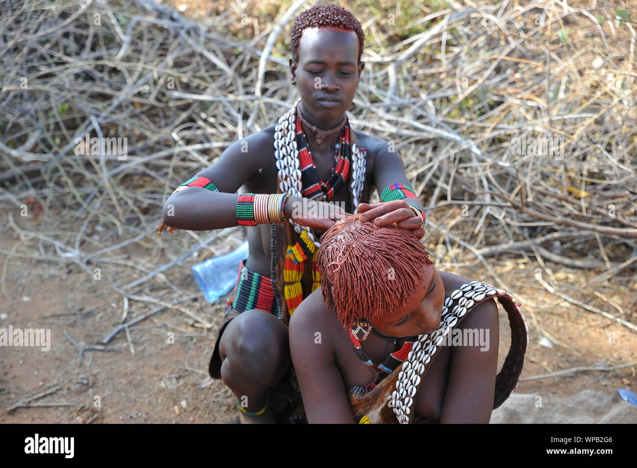 Making the typical red hair red of the Hamer tribe in the south of ...