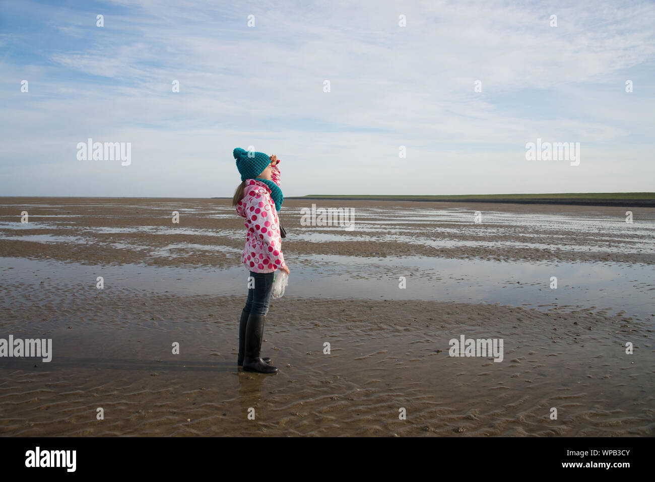 lonely child during mudflat hiking tour in northern sea Stock Photo