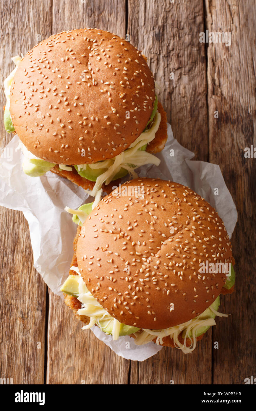 Mexican Cemita sandwich with meat, cheese, avocado and sauce close-up on the table. Vertical top view from above Stock Photo