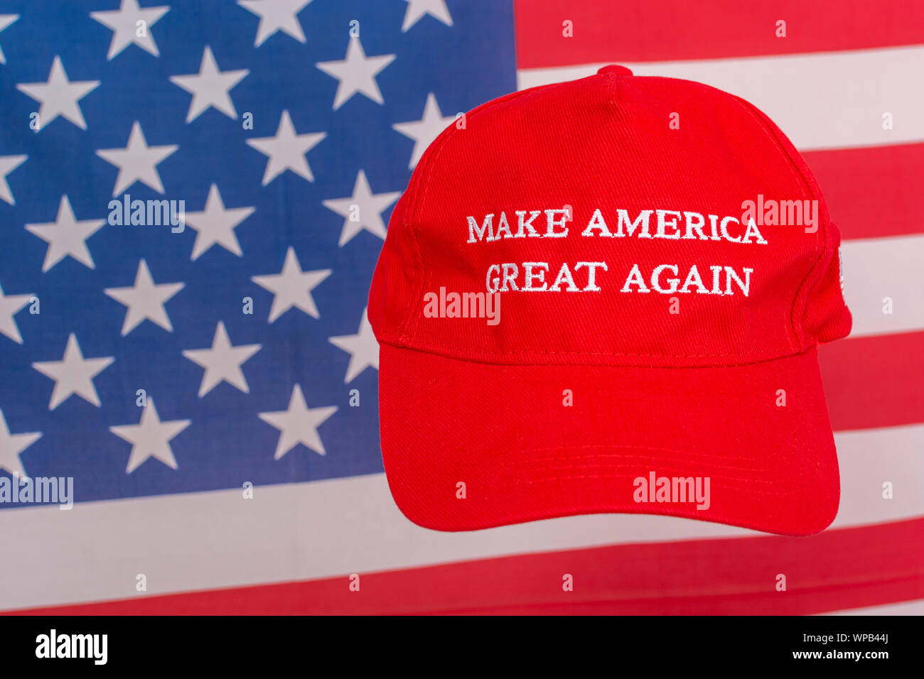 Red Donald Trump MAGA cap and U.S Stars & Stripes flag. Metaphor Maga hats, Trump supporters, Trump presidency, 2024 US elections, Trump America first Stock Photo