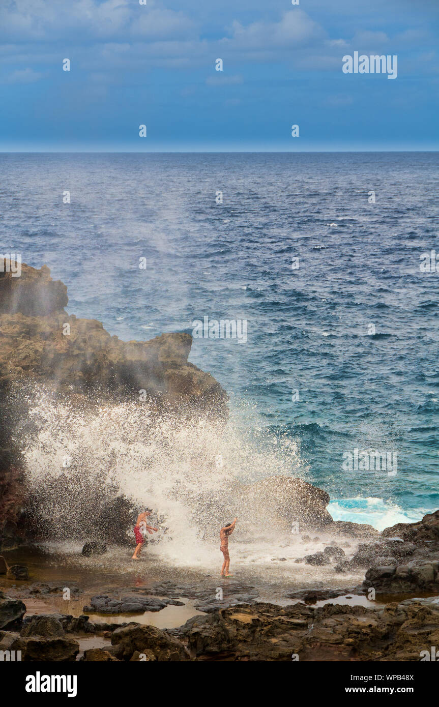 Tourists looking at a blow hole on the Maui coastline, Hawaii, USA Stock Photo