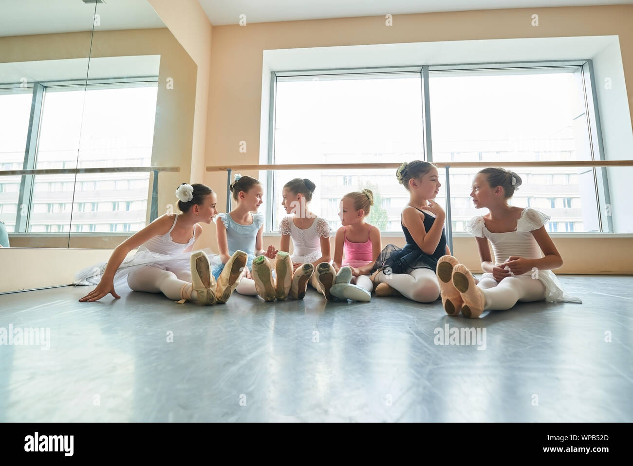 Group of ballerinas talking to each other in studio. Stock Photo