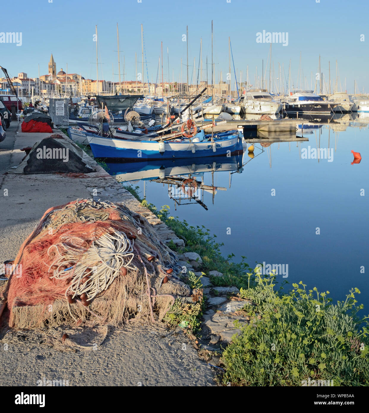 fishing net on the pier of the harbor of Alghero town, in Sardinia island, at the first light of morning Stock Photo