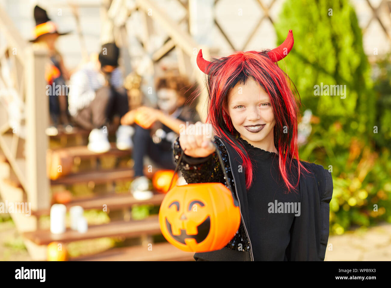 Portrait of cute little girl wearing Halloween costume looking at ...