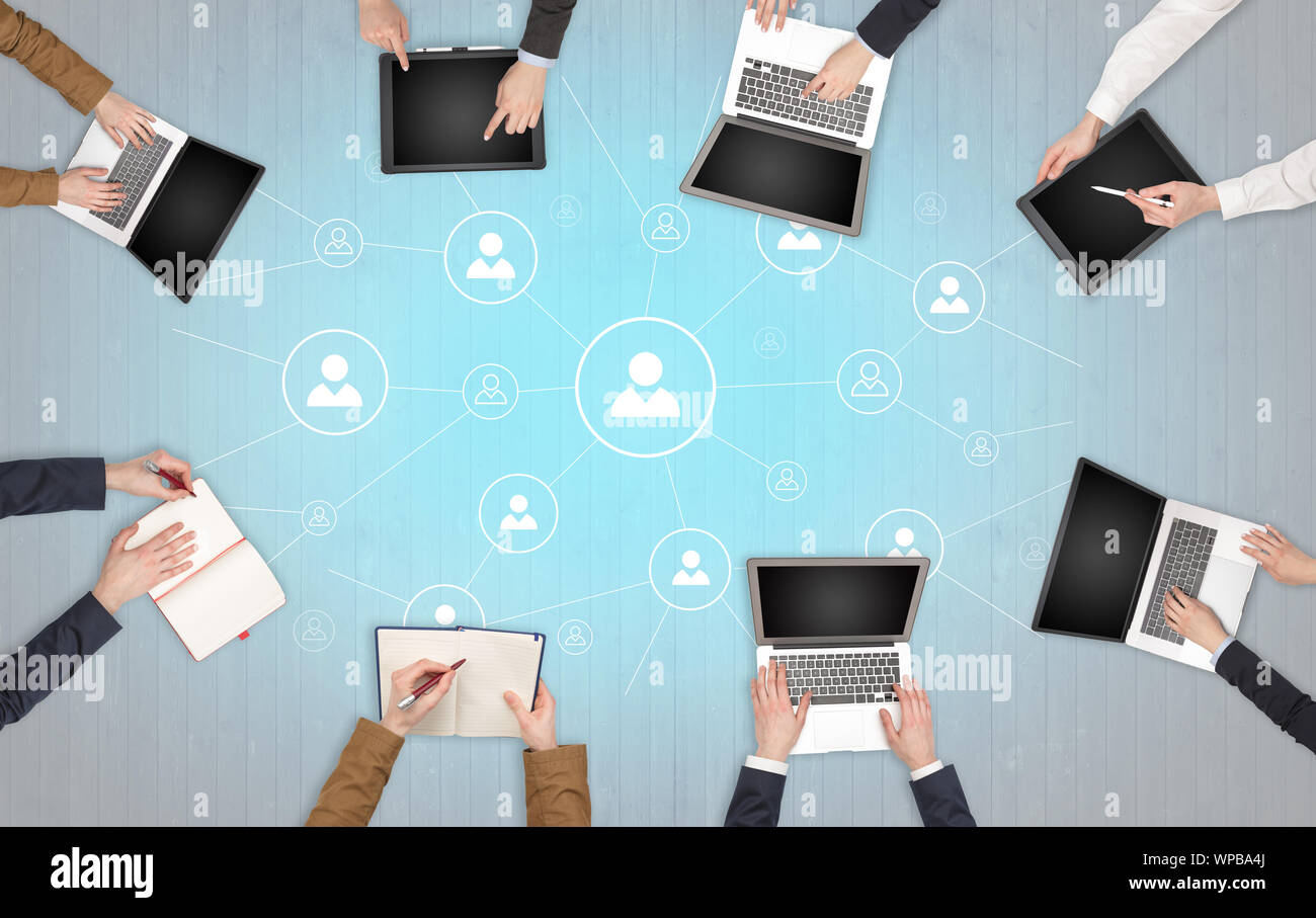 Group of people with devices in hands working in team on tablets ...
