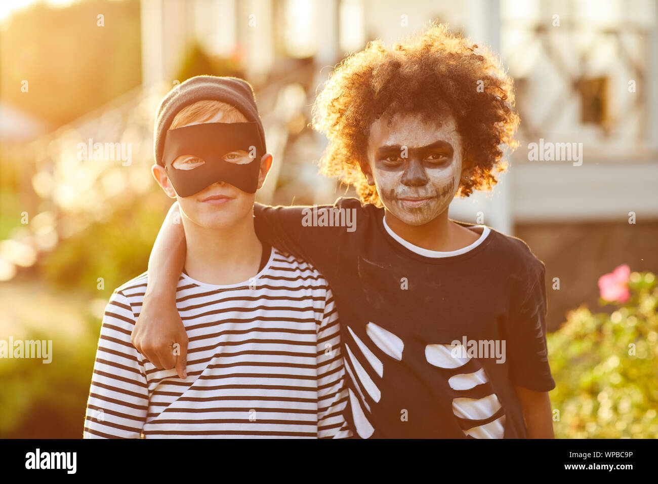 Waist up portrait of two boys wearing Halloween costumes posing