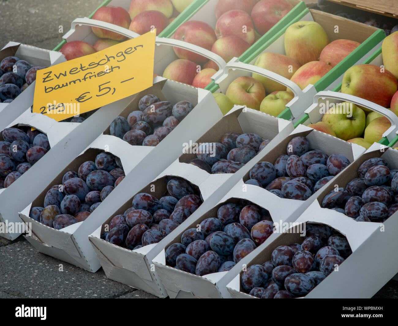 Fresh plums and apples on German market with sign 'Zwetschgen' Stock Photo