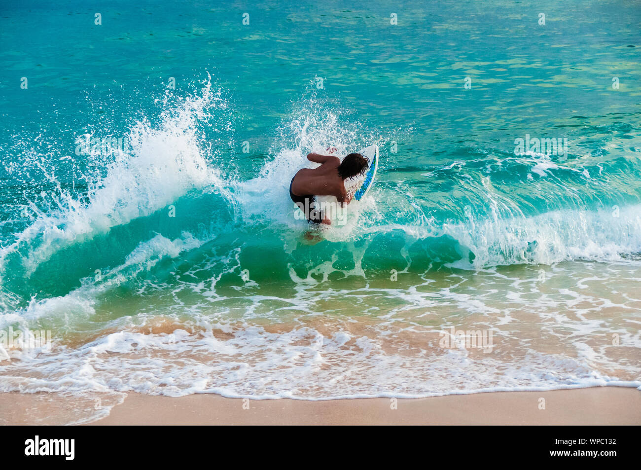 Teenage boy skimboarding on the tropical island of Kauai, Hawaii, USA Stock Photo Alamy
