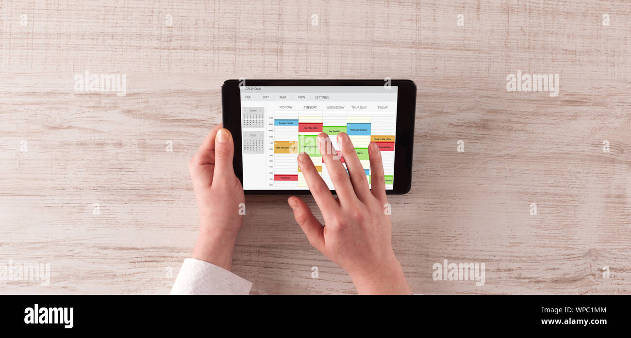 Hand holding tablet with timetable and calendar concept Stock Photo - Alamy