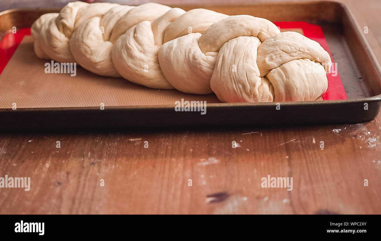 Step by step. Braded challah dough in loaf of bread on baking sheet