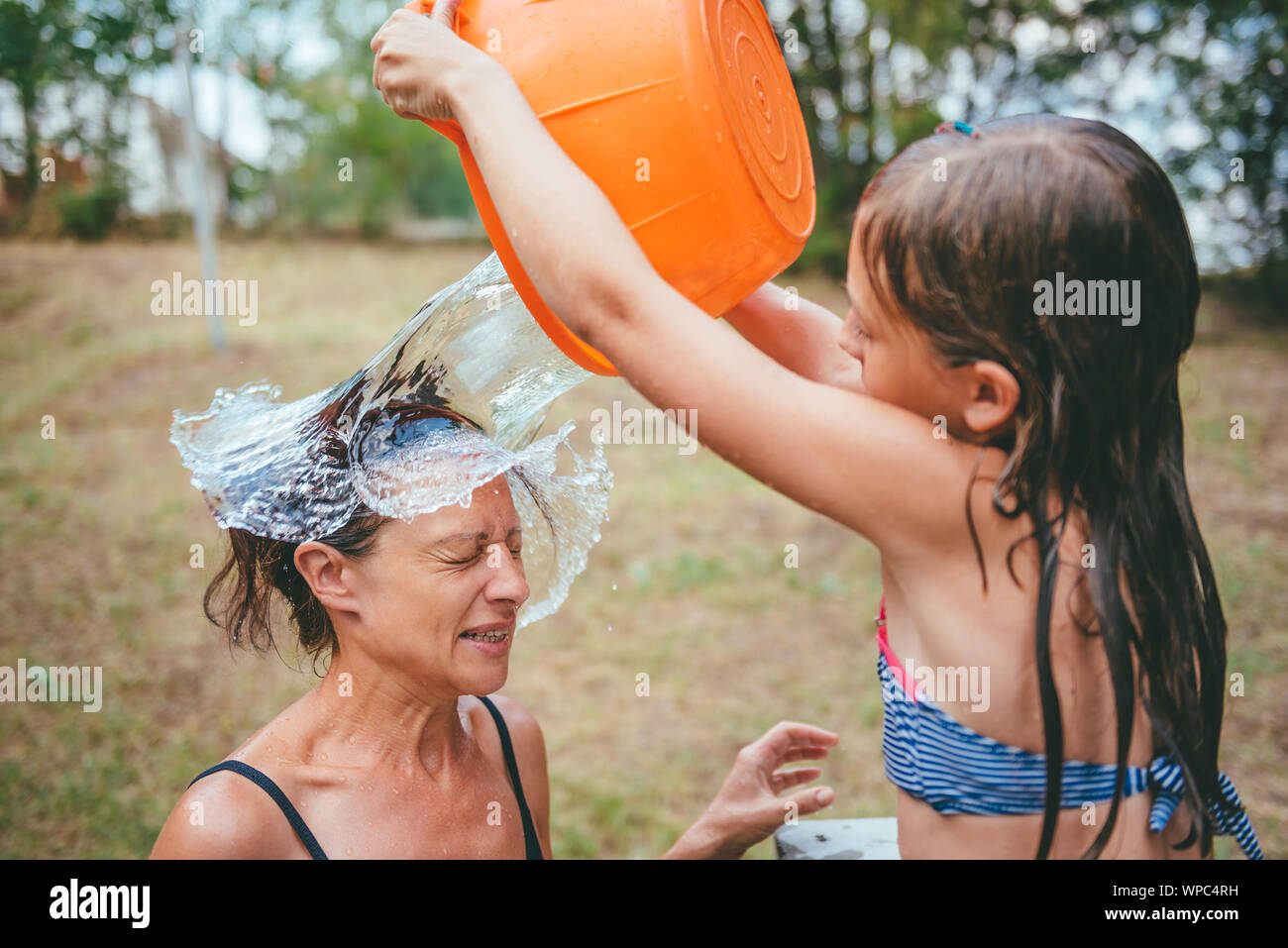 Mother getting splashed by a stream of water in her face Stock Photo