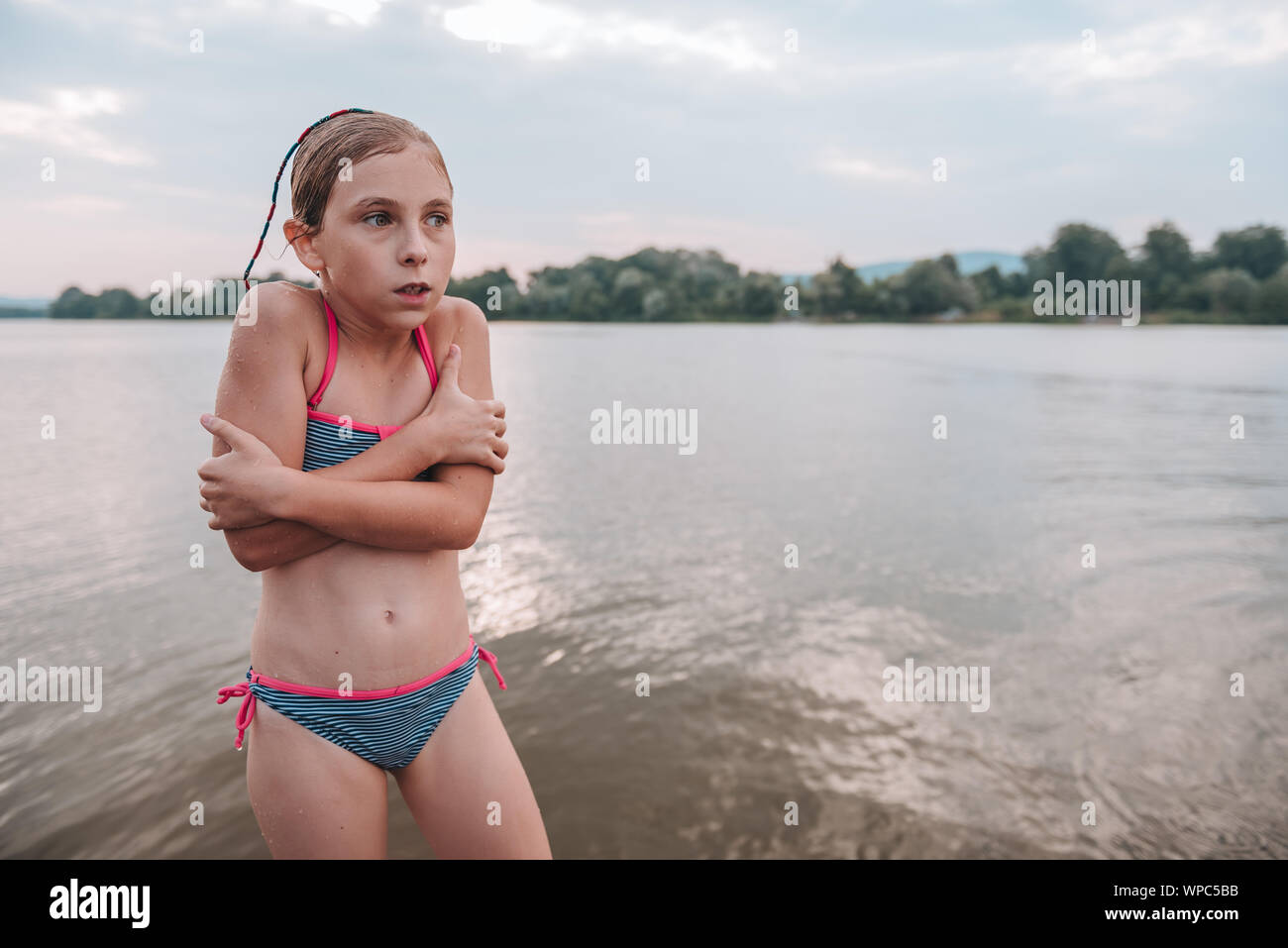 Girl shivering after a swim in the freezing cold river Stock Photo