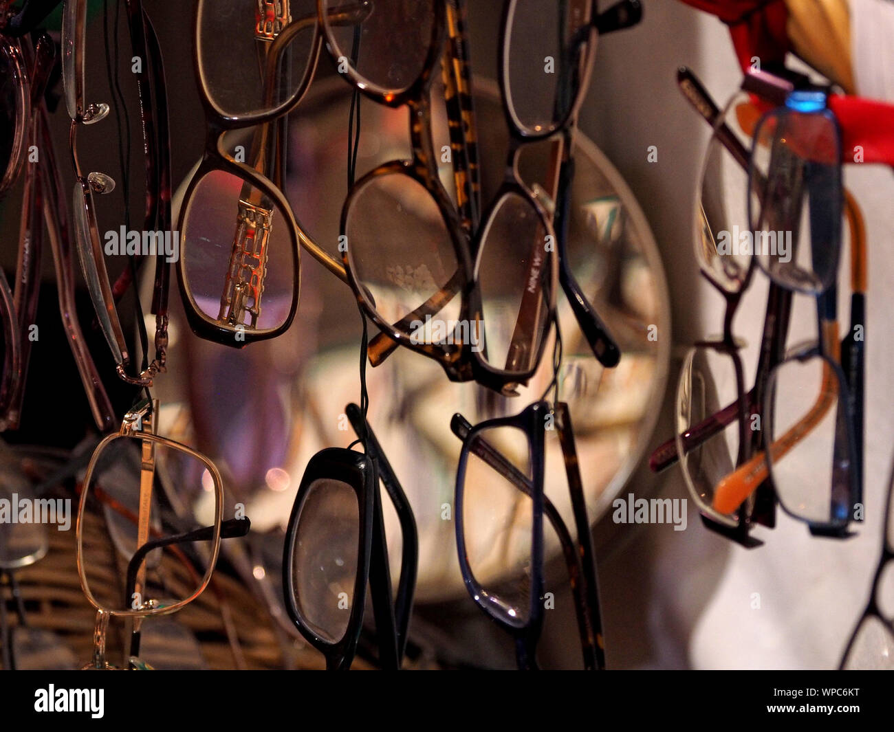 display of collection of eyeglass spectacles hanging vertically with