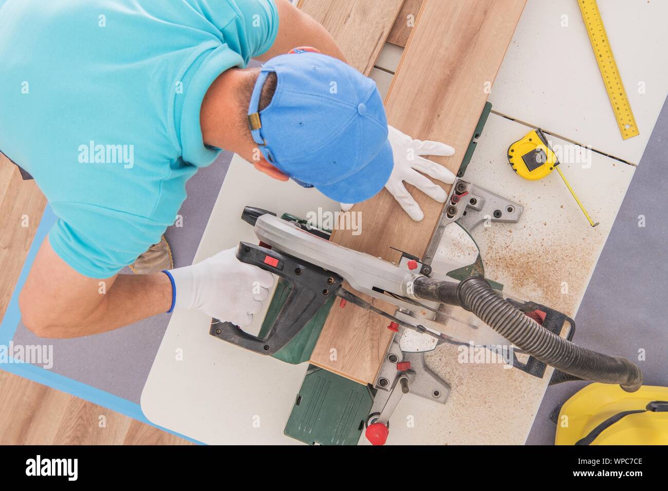 Caucasian Contractor Cutting Wood Panels Using Stationary Circular Saw