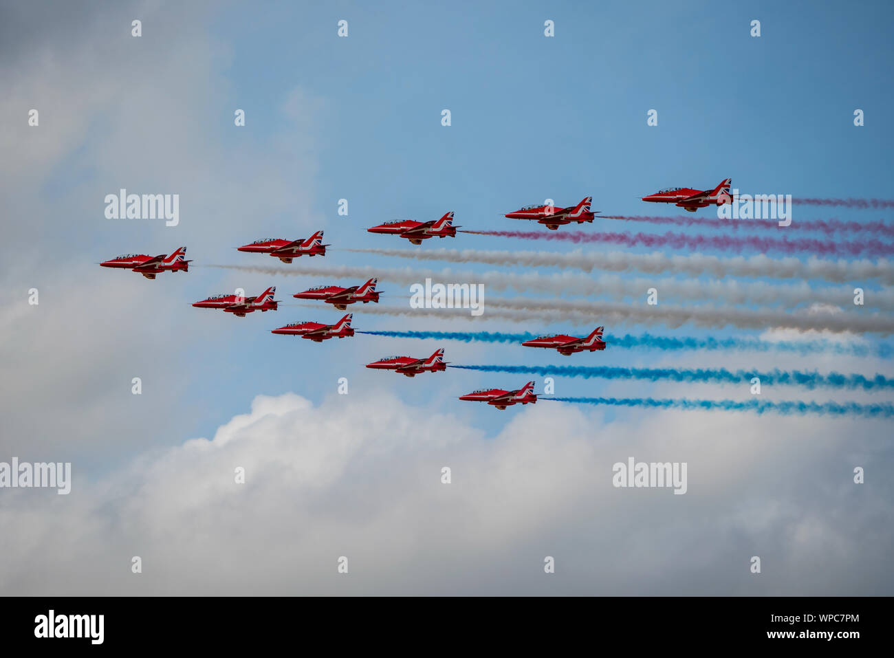 The RAF Red Arrows display team trail red, white and blue smoke in Big Battle (plus 2 aircraft) formation for RIAT 2019 at RAF Fairford on 21/7/19. Stock Photo