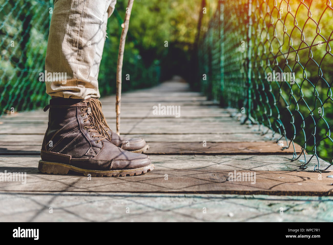 Hikers boots on the wooden suspension bridge in the forest Stock Photo