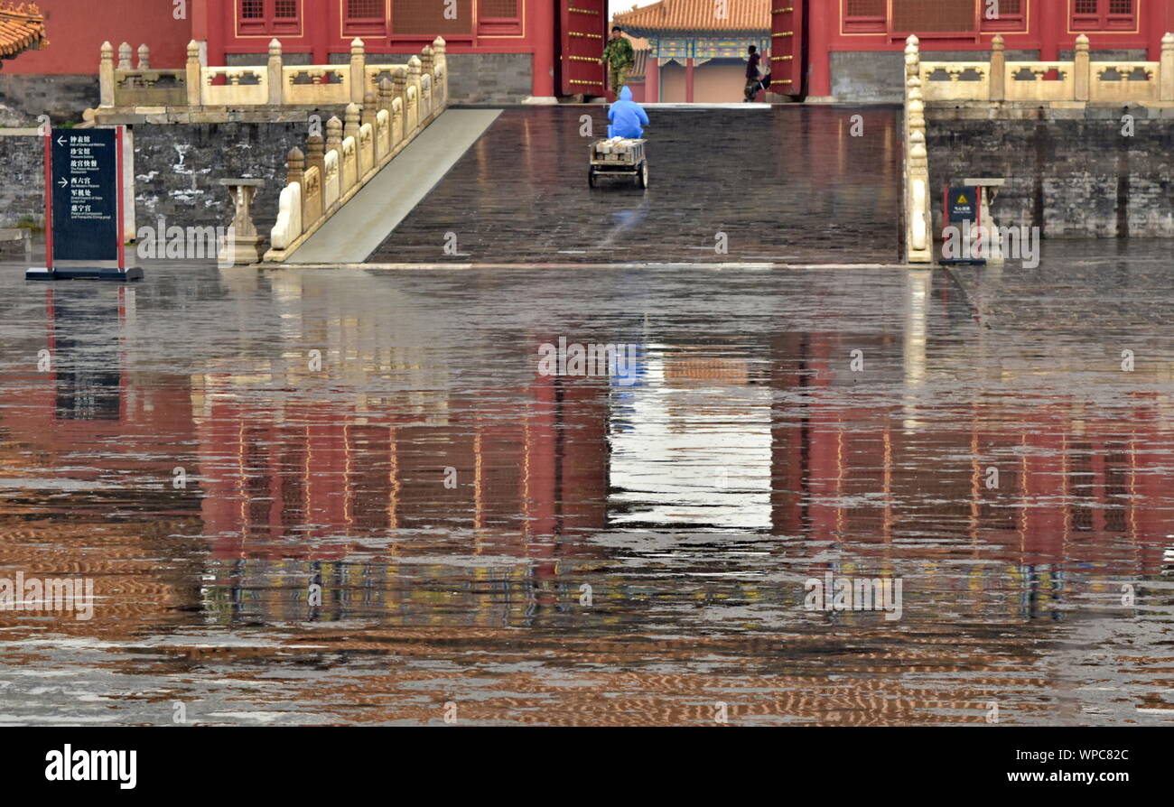 Landmark Chinese architecture of Forbidden City palace gate water reflected on rain puddles, Beijing, China Stock Photo