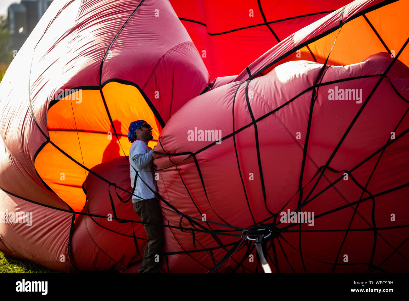 Lancaster, Pennsylvania, USA. 7 September, 2019. Hundreds gathered in a field in Bird-In-Hand, Pennsylvania for the second day of the annual Hot Air Balloon Festival. High winds prevented any balloons from launching, but crews organized a twilight 'flaring'. Credit: Chris Baker Evens/Alamy Live News. Stock Photo