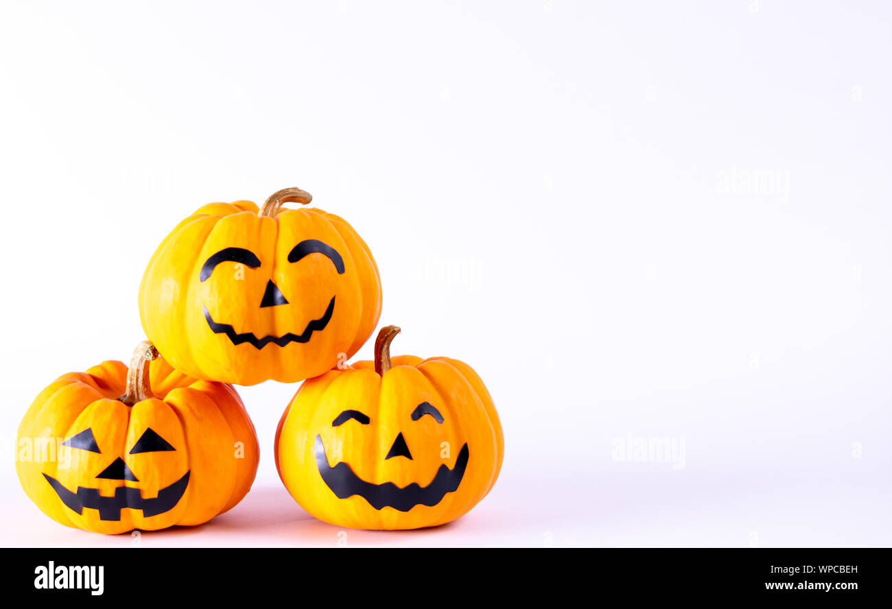 Halloween concept. orange pumpkin jack o lantern decor with funny faces over white background. Stock Photo
